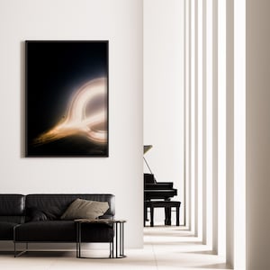 May include: A framed art print depicting a black hole with a bright, glowing ring of light against a dark background. The artwork hangs on a white wall above a black leather sofa. A black piano is visible in the background.