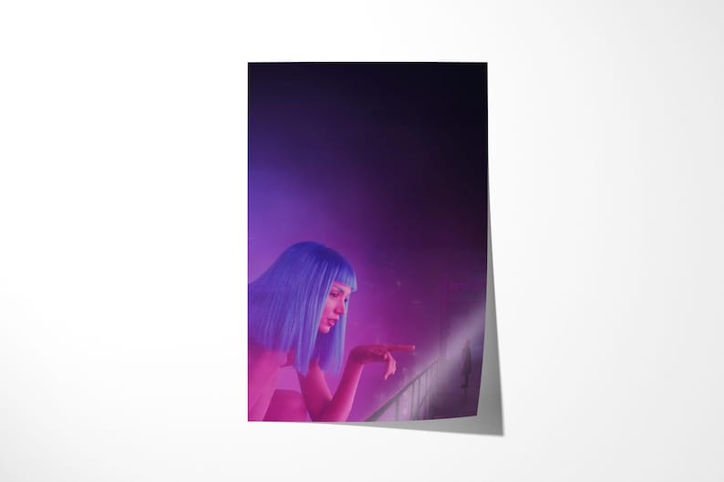 May include: A poster featuring a woman with blue hair, illuminated by pink and purple lighting. She is pointing towards a bright area, creating a futuristic and cinematic aesthetic. The background is a gradient of dark purple.