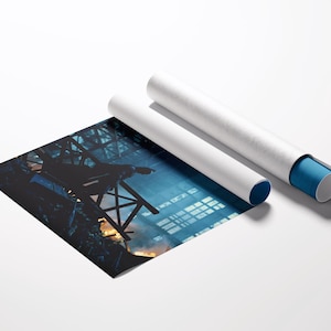 May include: A print of an industrial scene with a blue and orange color palette, next to two white poster tubes. One tube has a blue end cap. The print shows a dark silhouette of a structure against a bright background.