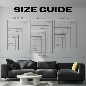 May include: A size guide chart with dimensions in inches and centimeters. The chart displays sizes for ISO A1-A4, Ratio 2:3, and Ratio 3:4 formats. The text "SIZE GUIDE" is at the top. A black sectional sofa and white coffee table are in the foreground.