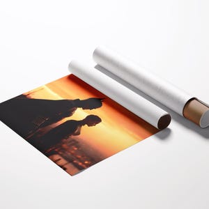 Puede incluir: Una impresi&oacute;n que muestra siluetas de dos personas contra un atardecer. La impresi&oacute;n est&aacute; parcialmente desenrollada, revelando la imagen, con dos impresiones enrolladas en tubos blancos.