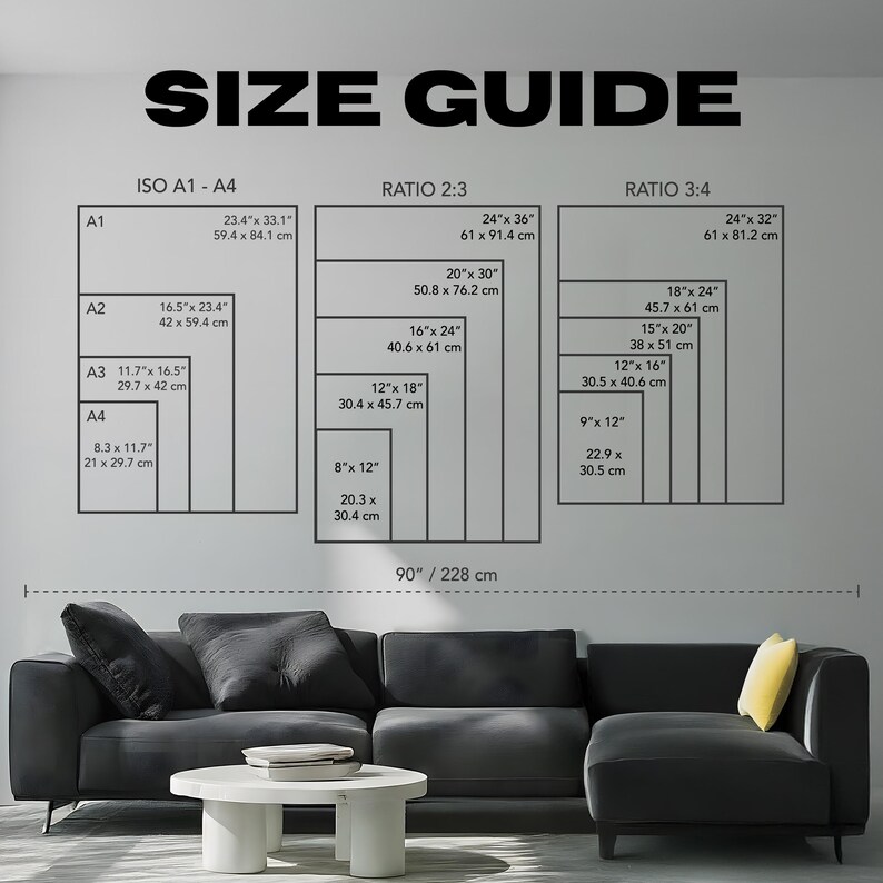 Op de afbeelding: Een maattabel met afmetingen in inches en centimeters. De tabel toont maten voor ISO A1-A4, Ratio 2:3 en Ratio 3:4 formaten. De tekst "SIZE GUIDE" staat bovenaan. Een zwarte hoekbank en een witte salontafel staan op de voorgrond.