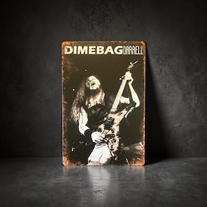May include: Metal sign featuring a black and white image of Dimebag Darrell playing guitar. The sign has a distressed, rusty appearance with the text "DIMEBAG DARRELL" at the top. The image shows Darrell with long hair, mid-performance.