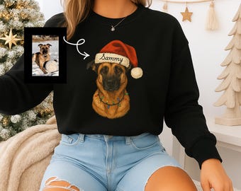 May include: Black sweatshirt featuring a dog wearing a Santa hat with the name "Sammy" on it. The dog has a string of colorful lights around its neck. A framed photo of the dog is on the left.