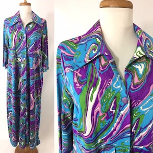 May include: A long-sleeved dress with a button-up front and a swirling abstract pattern in shades of blue, purple, green, pink, and white.