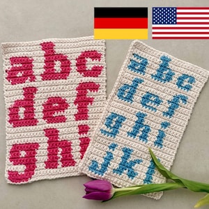 Könnte beinhalten: Zwei gehäkelte Quadrate mit den Buchstaben a bis i. Eines zeigt rosa Buchstaben, das andere blaue. Die Quadrate sind cremefarben mit einer gehäkelten Textur. Eine lila Tulpe ist im Vordergrund.