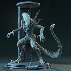 Op de afbeelding: Een gedetailleerd, grijs Xenomorph-figuur, een wezen uit de Alien-filmreeks, staat op een cirkelvormig platform. Het figuur heeft een lange, gesegmenteerde staart, een langwerpige kop en uitgestrekte armen. Het poseert dreigend.