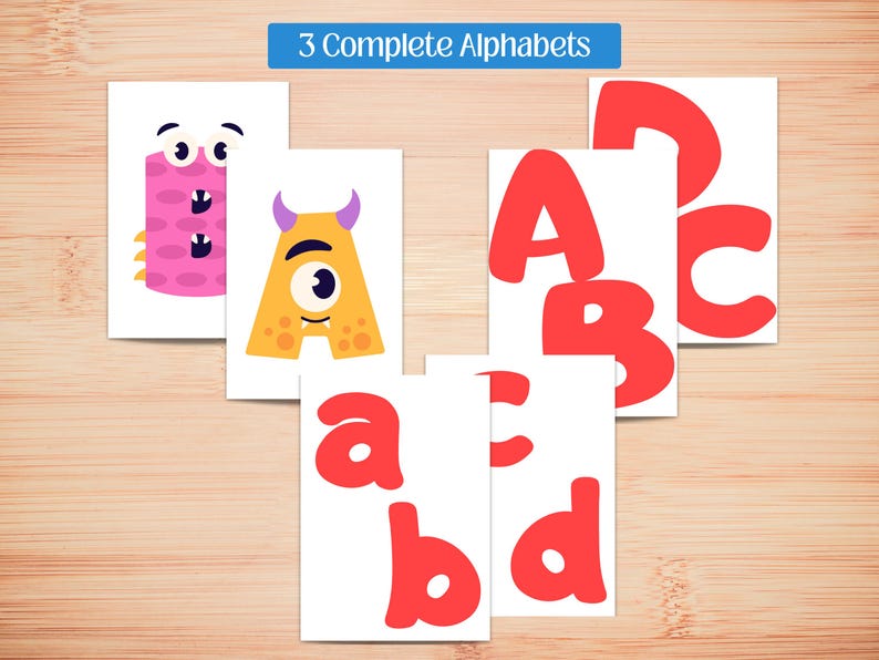 May include: Educational flashcards featuring the alphabet. The cards display uppercase and lowercase letters in red, along with whimsical monster illustrations for each letter. The text "3 Complete Alphabets" is at the top.