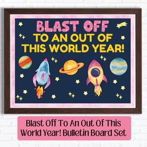 May include: A framed bulletin board set with a dark blue background featuring the text BLAST OFF TO AN OUT OF THIS WORLD YEAR! in pink and yellow. The design includes watercolor illustrations of two rockets, two planets, and yellow stars.