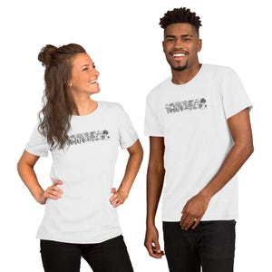 Puede incluir: Camisetas blancas con un diseño gráfico en blanco y negro. El diseño presenta una línea de varias ilustraciones de hongos. Las camisetas son de manga corta y las llevan dos personas.