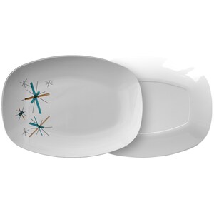 May include: A white oval serving platter with a teal and brown starburst design. The platter is shown with a matching white oval platter underneath.