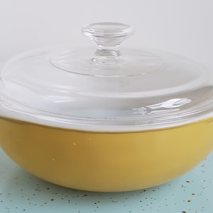 May include: A yellow glass baking dish with a clear glass lid. The lid has a clear glass knob.