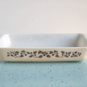 May include: White rectangular baking dish with a brown floral design around the rim.