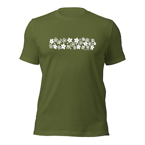 Könnte beinhalten: Ein grünes T-Shirt mit einem weißen Design aus einer Reihe von Blumen.