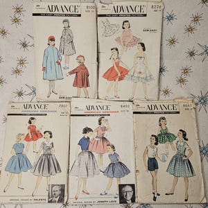 May include: Five vintage Advance sewing pattern envelopes featuring illustrations of children's clothing designs. The envelopes are labeled with pattern numbers 8100, 8226, 7807, 8402, and 8660, showcasing various dress styles, coats, and separates.
