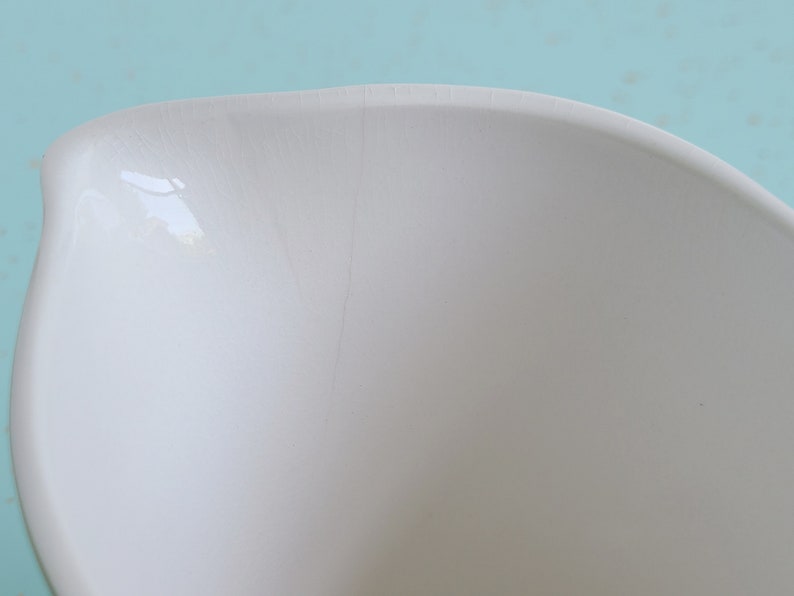 Puede incluir: Un taz&oacute;n mezclador de cer&aacute;mica blanca con una peque&ntilde;a grieta en el lateral.