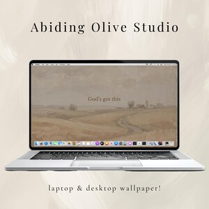 May include: A silver laptop showing a landscape wallpaper with the text "God's got this." The screen has a black border. The words "Abiding Olive Studio" and "laptop & desktop wallpaper!" are above and below the laptop.