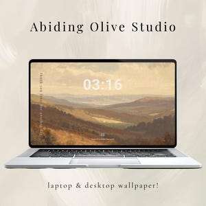 May include: A silver laptop displaying a landscape wallpaper with a mountain range and a clock that reads 03:16. The text "Abiding Olive Studio" and "laptop & desktop wallpaper!" are also visible.