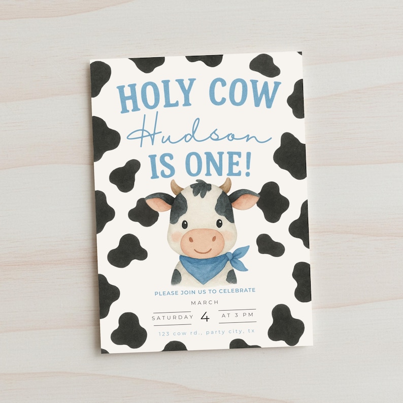May include: A rectangular invitation card with a cow theme. The text "HOLY COW Hudson IS ONE!" is written in blue and black. A cartoon cow illustration is in the center. The card also includes event details: date, time, and location.