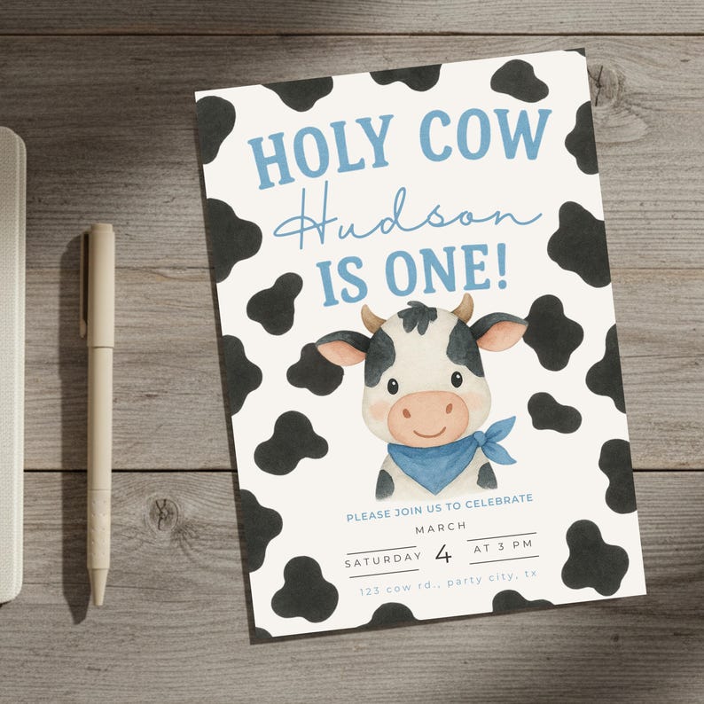 May include: A white invitation card featuring a cow design. The text "HOLY COW Hudson IS ONE!" is in blue, with a cartoon cow illustration. Black cow spots surround the text. The invitation includes event details.