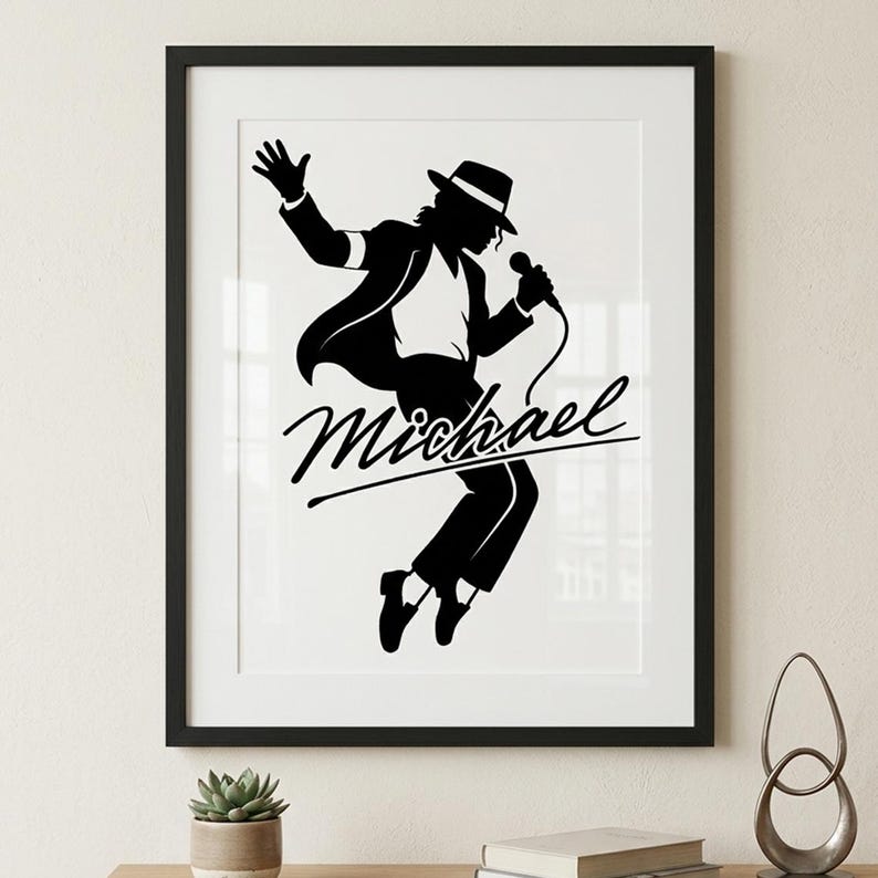 Puede incluir: Impresi&oacute;n enmarcada en blanco y negro que presenta una silueta de un artista con sombrero y traje, sosteniendo un micr&oacute;fono. El nombre "Michael" est&aacute; escrito en cursiva debajo de la figura. La impresi&oacute;n se muestra en una pared clara.