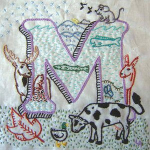 Può includere: Lettera M ricamata con vari animali e scene di natura. La lettera è viola e contornata di nero. Gli animali includono un alce, una mucca, un asino, un topo e un'anatra. Le scene di natura includono un pesce, una foglia e una montagna.