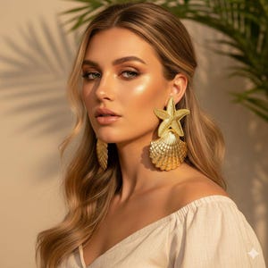 Op de afbeelding: Goudkleurige statement oorbellen met een zeester- en schelpmotief. De oorbellen zijn groot en sierlijk, met ingewikkelde details. Een opvallend accessoire, perfect om een vleugje glamour aan elke outfit toe te voegen.