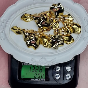 Digital scale showing a pair of long statement earrings weighing only 13.28 grams total, highlighting that each earring is ultra-lightweight at 6.6g.
