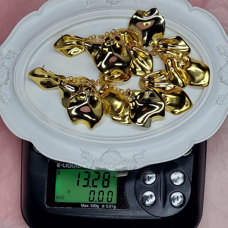 Digital scale showing a pair of long statement earrings weighing only 13.28 grams total, highlighting that each earring is ultra-lightweight at 6.6g.