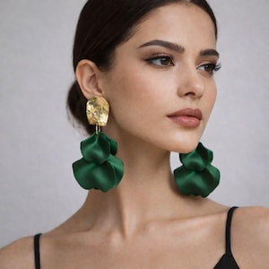May include: Gold-tone earrings with a textured, irregular top and cascading, layered, emerald green fabric petals. The earrings are a statement piece, adding a pop of color and texture to any outfit.
