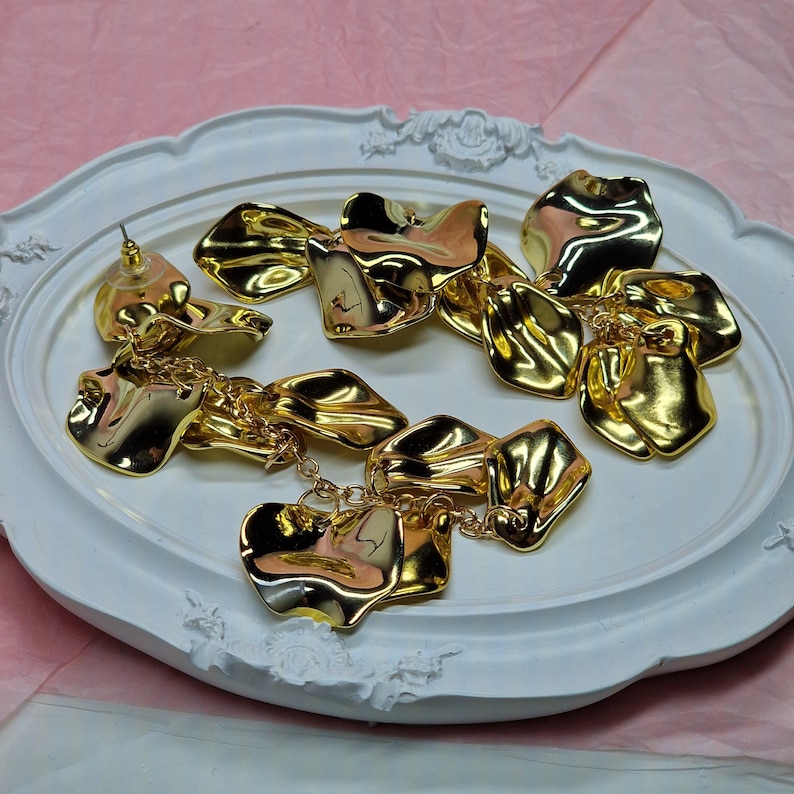 A collection of long gold leaf statement dangles, showing the consistent high quality and vibrant golden tone of the entire batch.