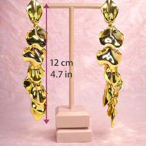 Large gold leaf dangles placed next to a ruler to demonstrate their impressive 12cm (4.7 inch) statement length.