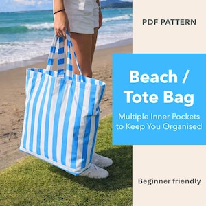 May include: A blue and white striped beach tote bag with multiple inner pockets. The bag is held by a person on a beach with the ocean in the background. Text on the image says "Beach / Tote Bag" and "Multiple Inner Pockets to Keep You Organised."