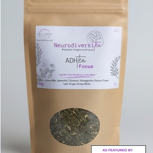 May include: A brown paper bag of NeurodiversiTea, with a clear oval window showing the tea leaves. The label reads "ADH/tea Focus" and lists ingredients. The bag is marked "50g" and "As Featured by Kirsty Gallagher."