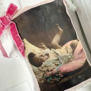 Cartão postal vintage de um bebê com laço de veludo rosa e sachê com acabamento branco