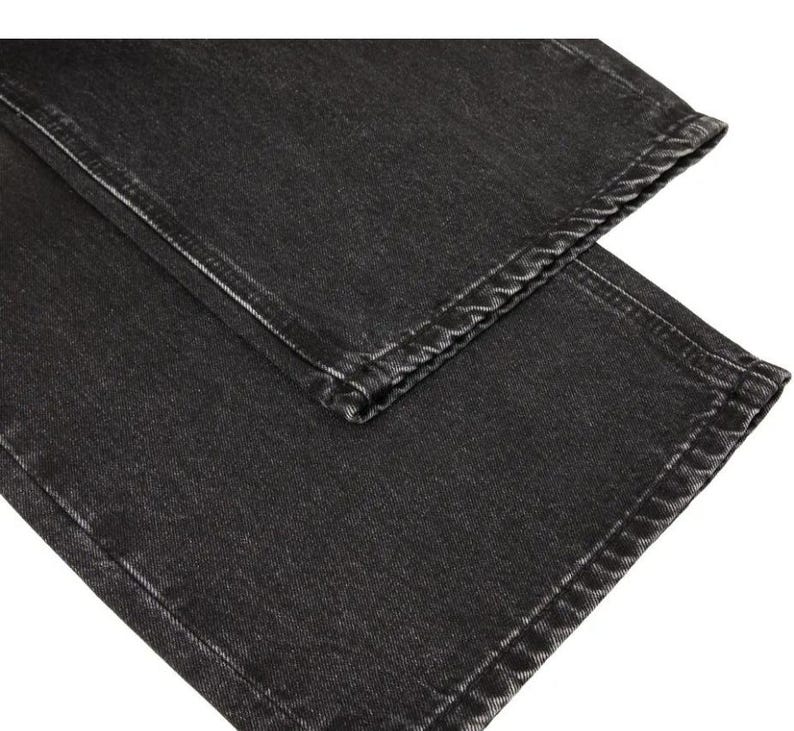 May include: A pair of charcoal black denim jeans featuring a straight leg cut with visible stitching along the hems and side seams. The fabric has a slightly faded, washed-out texture throughout, showcasing the classic weave of the cotton denim material.