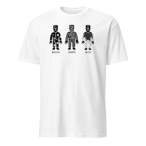 May include: White t-shirt featuring three stylized black figures labeled "BOLTS," "CHIPS," and "BITS." Each figure has a unique design, resembling mechanical or digital components. The shirt is a casual, unisex style.