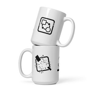 Könnte beinhalten: Zwei weiße Keramikbecher, die übereinander gestapelt sind. Der obere Becher hat eine schwarze Grafik aus Quadrat, Kreis und Linien. Der untere Becher hat eine schwarze Grafik eines zerbrochenen Quadrats.