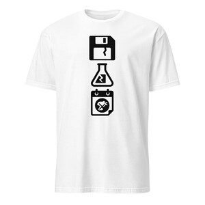 May include: White t-shirt with a black graphic. The design features a floppy disk, a laboratory flask, and a calendar icon, arranged vertically. The graphic is simple yet striking, making a bold statement.
