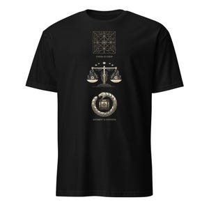 May include: Black t-shirt with a gold graphic design. The design includes a geometric shape, a scale, and a circular emblem. The text "SYNTAX IS CHEAP" and "JUDGMENT IS EXPENSIVE" are also included in the design.