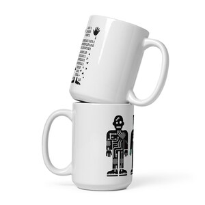 Könnte beinhalten: Zwei weiße Keramikbecher, einer auf dem anderen gestapelt. Der obere Becher hat Binärcode und eine Handgrafik. Der untere Becher zeigt ein schwarzes Roboterdesign. Beide Becher haben einen großen Henkel.