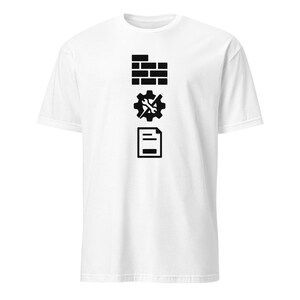 May include: White t-shirt featuring three black graphic icons: a brick wall, a gear with a wrench, and a document. The icons are vertically aligned. The shirt is made of a soft, comfortable material.