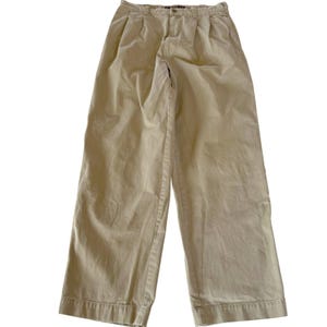 Op de afbeelding: Kleur kaki geplooide broek met een wijd model. De broek heeft een knoop- en ritssluiting, riemlussen en twee voorzakken. De stof lijkt een stevige katoenmix te zijn.
