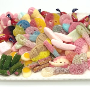 May include: A white, scalloped-edge platter overflowing with a colorful assortment of candies. The sweets include gummy bears, sour straws, and wrapped candies in various shapes and colors, perfect for a party or a sweet treat.