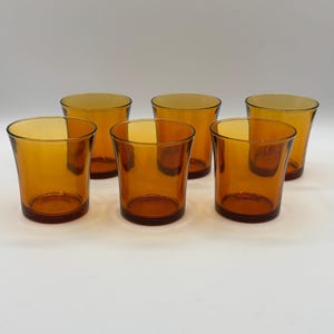 Op de afbeelding: Een set van drie keramische mokken met een gespikkelde, matte afwerking. De mokken zijn in crème, lichtgrijs en donkergrijstinten. Elke mok heeft een eenvoudig, minimalistisch ontwerp en een afgeronde handgreep.