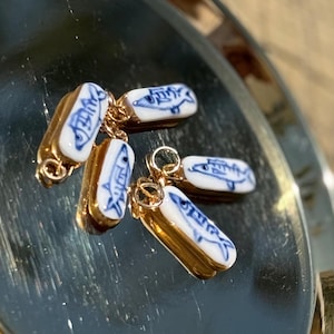 Porcelain Blue Fish Charm, handmade hand painted with 22k gold luster frame on a gold-filled Jump ring for easy slide on any necklace