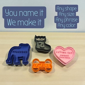 May include: An assortment of cookie cutters in various shapes and colors. The cutters include a blue bulldog, a gray boot with the number 2, an orange bone shape with the word "YOUT", and a pink heart. Text on the image reads "You name it, We make it."