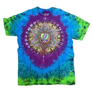 May include: Tie-dye t-shirt with a vibrant spiral design in shades of blue, green, and purple. The center features a detailed graphic with a skull and lightning bolt. The text "LIQUID BLUE" is visible at the top.