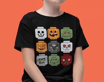 May include: Black t-shirt featuring a grid of nine Halloween-themed block figures. The figures include a skull, jack-o'-lanterns, monsters, and other spooky designs. The shirt is a fun and festive choice for Halloween.