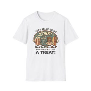 Peut inclure: T-shirt blanc avec un motif rétro de maïs soufflé, boisson, barre chocolatée et hot-dog animés. Le texte dit : « Allons au hall... et offrons-nous une gâterie ! » dans une police vintage.